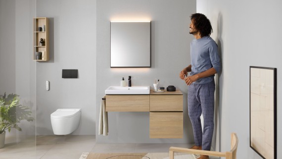 Homem numa casa de banho com Geberit AquaClean Sela