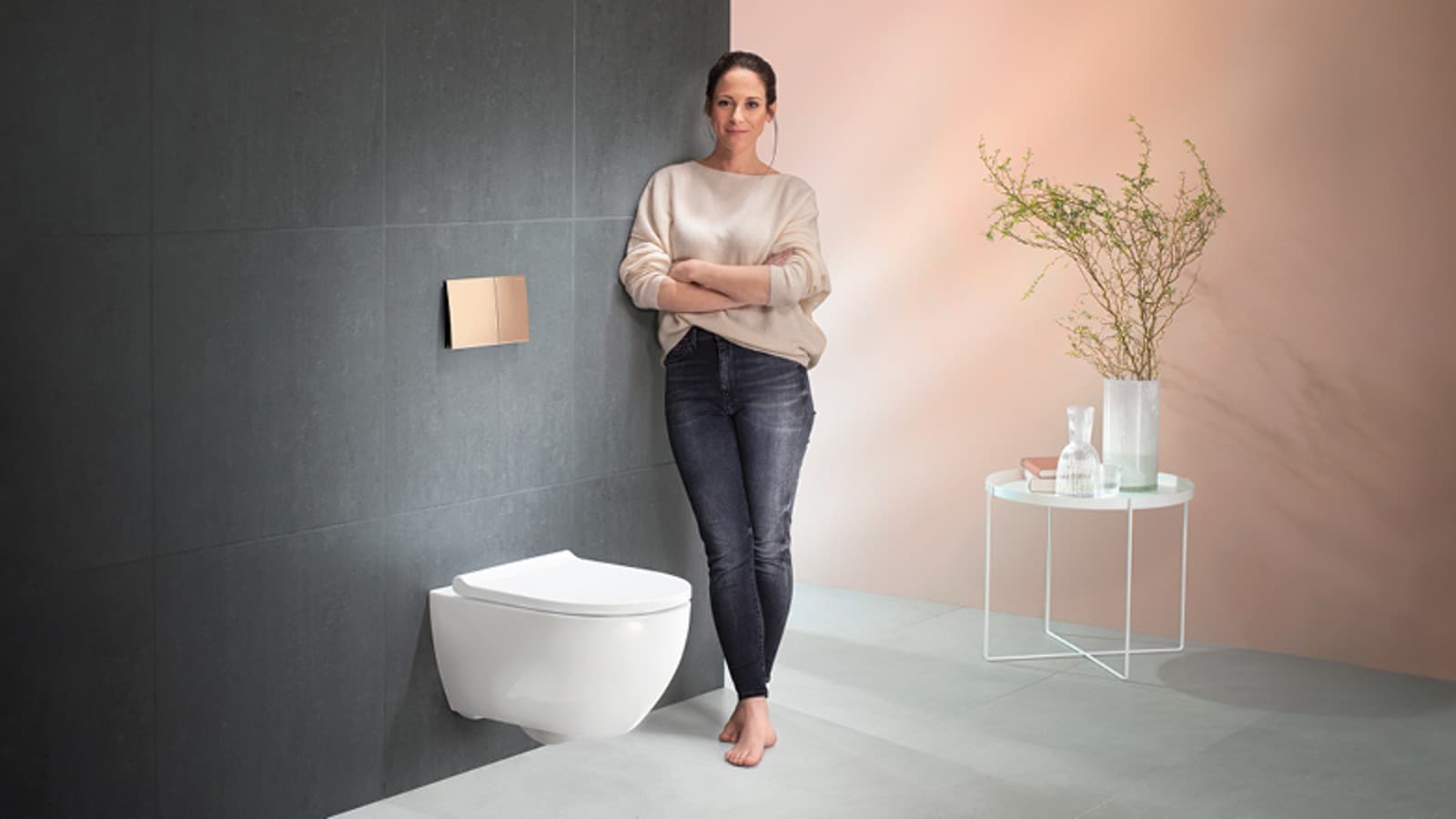 Mulher contente ao lado da sua sanita Geberit Acanto Mulher contente ao lado da sua sanita Geberit Acanto